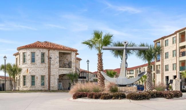 a building with palm trees and a fountain in front of it