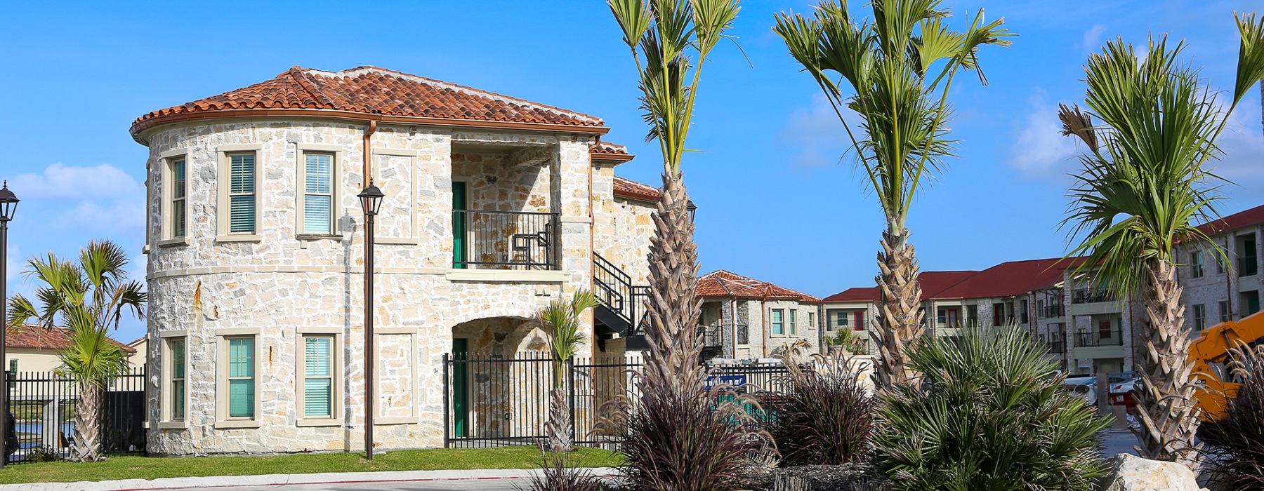 a building with palm trees and a road